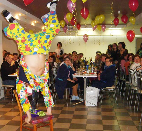 клоун стоит на руках на стульях