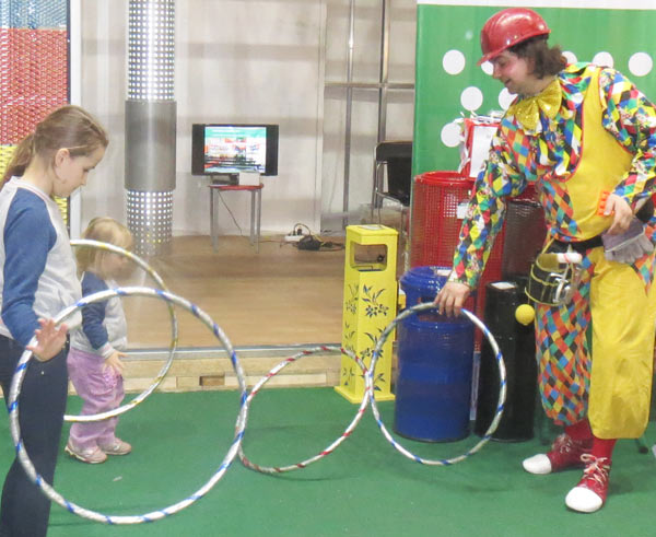 клоун играет с детьми на выставке