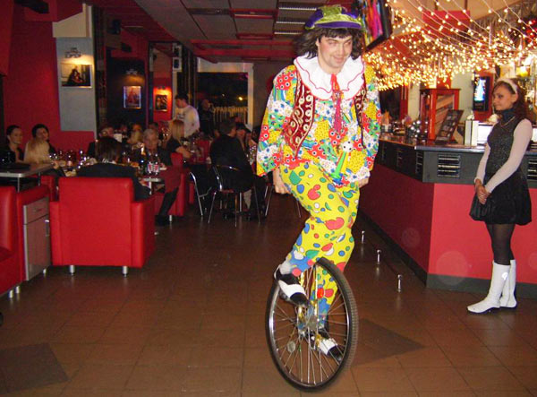 клоун на моноцикле в ресторане
