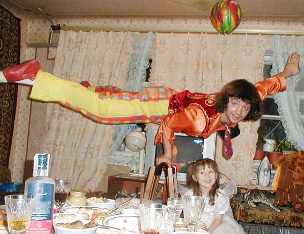 клоун делает стойку на руках дома на именинах девочки