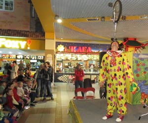 клоун балансирует моноцикл на голове